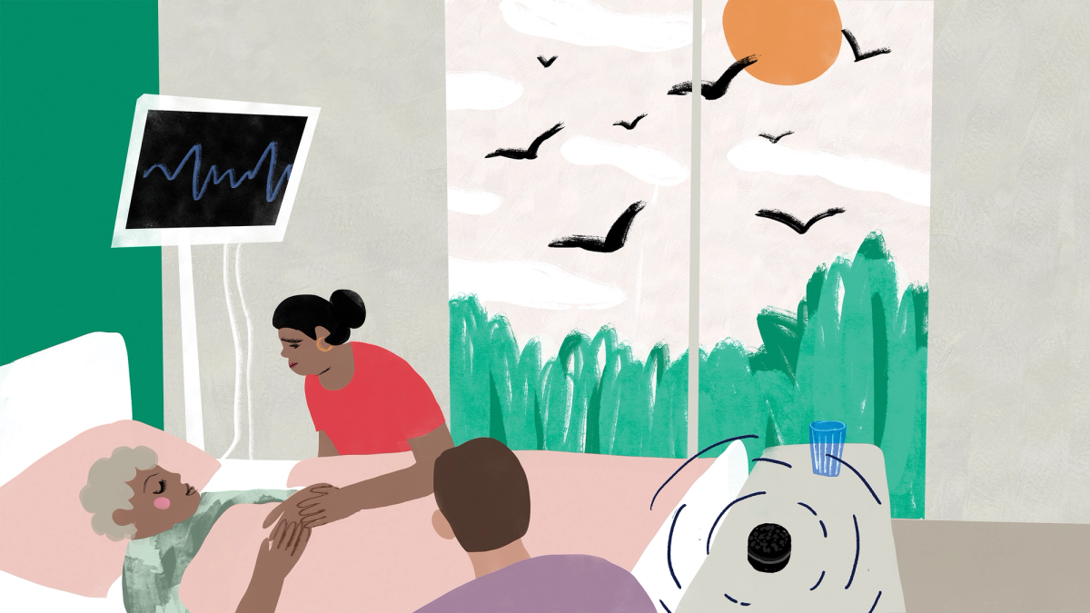 Loved ones gathered around a person in bed beside a medical monitor