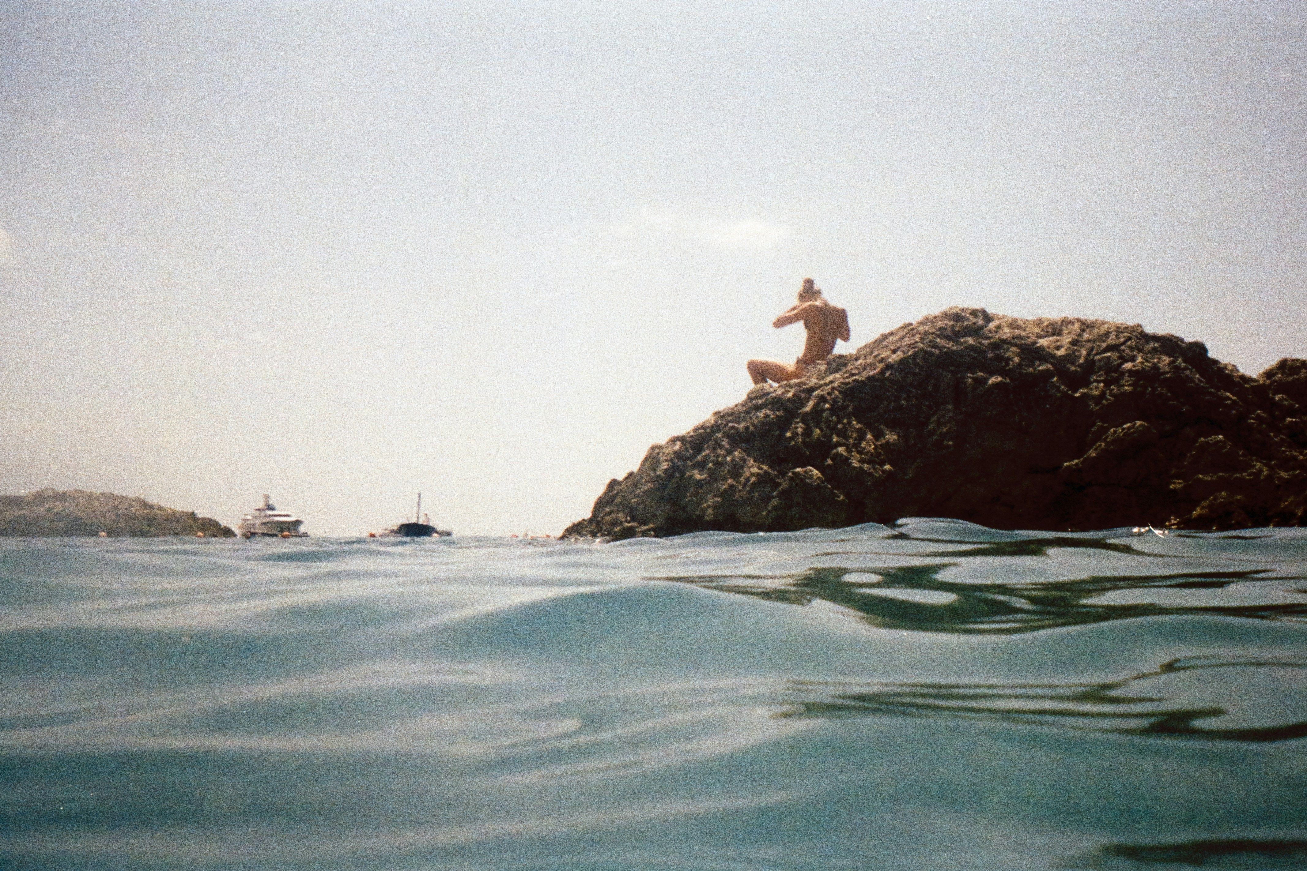 person on rock in water