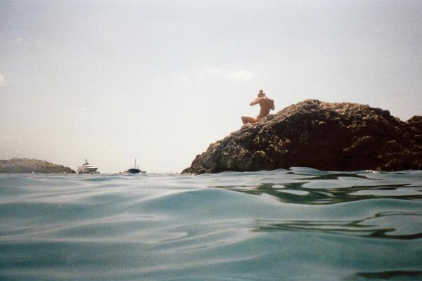 person on rock in water