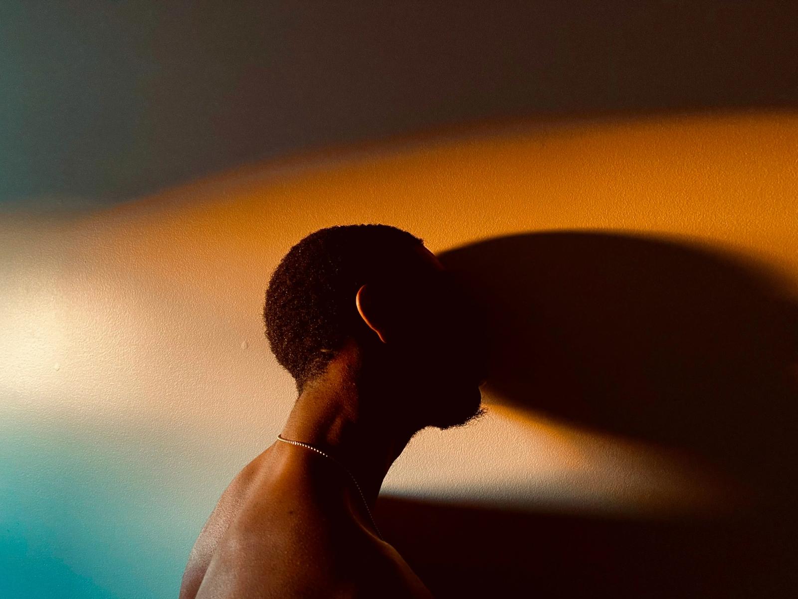Man with head against wall 