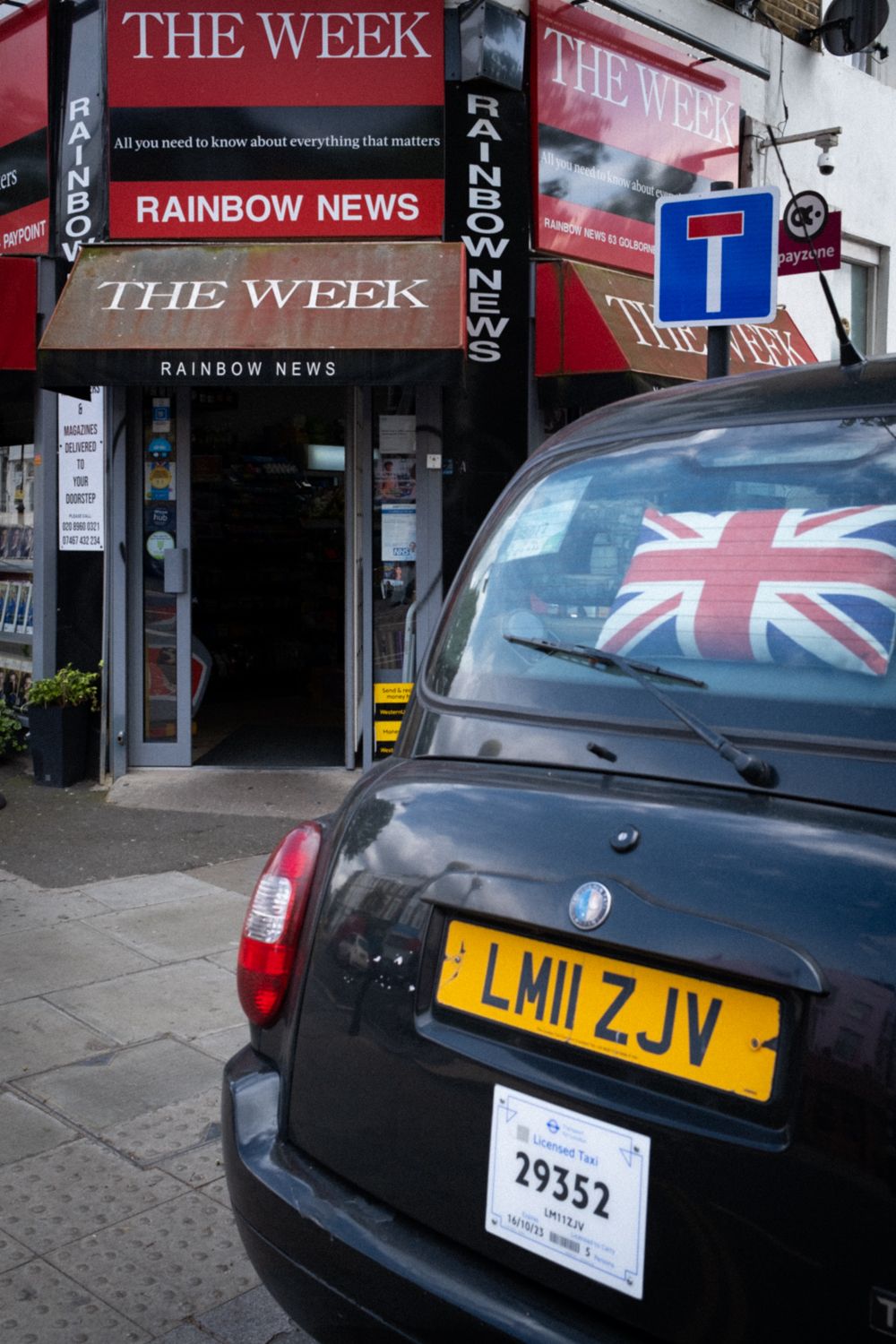 Street Photography von einem Londoner Taxi vor einem Zeitungskiosk in London