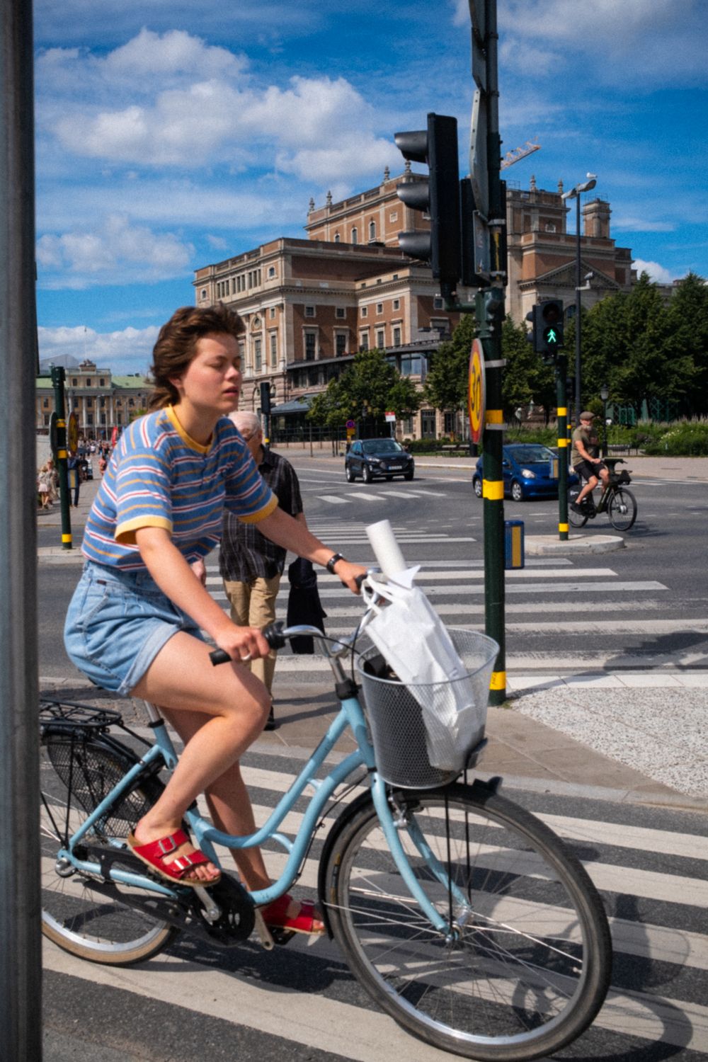 Fahrradfahrerin fährt vor der Oper in Stockholm über einen Zebrastreifen 