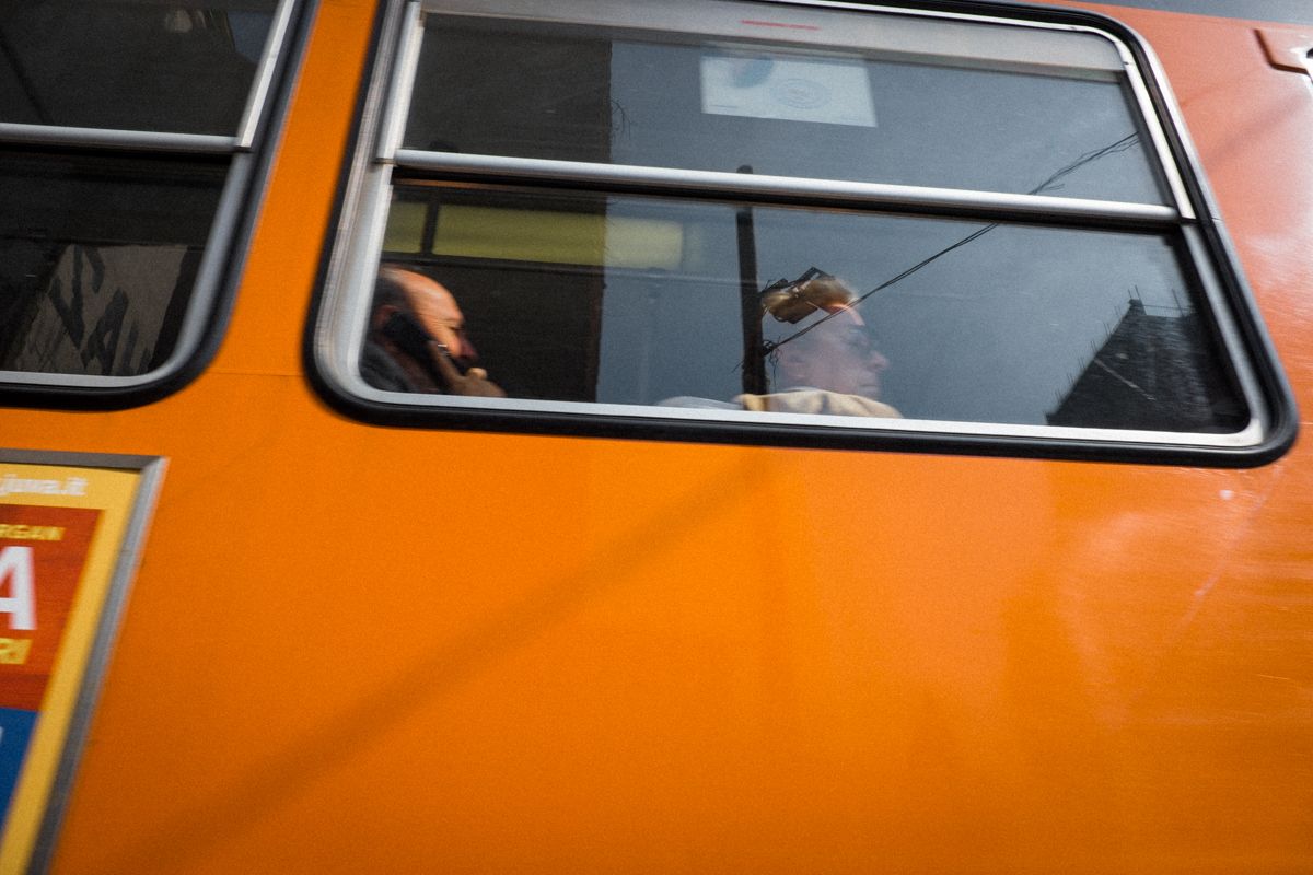 Street Photography Mailand - ganz eng fährt die Mailander Tram an den Passanten vorbei. Die Lackierung scheint direkt aus den 1970er Jahren zu stammen. Die satten Farben kommen in den Abendstunden besonders gut zur Geltung.