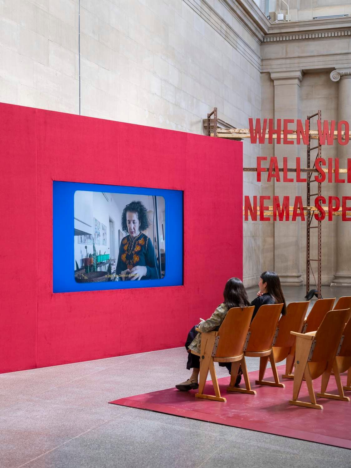 Screen built into the red cinema wall with tip-up seating, Zineb Sedira, When Words Fall Silent, Cinema Speaks…, Tate Britain