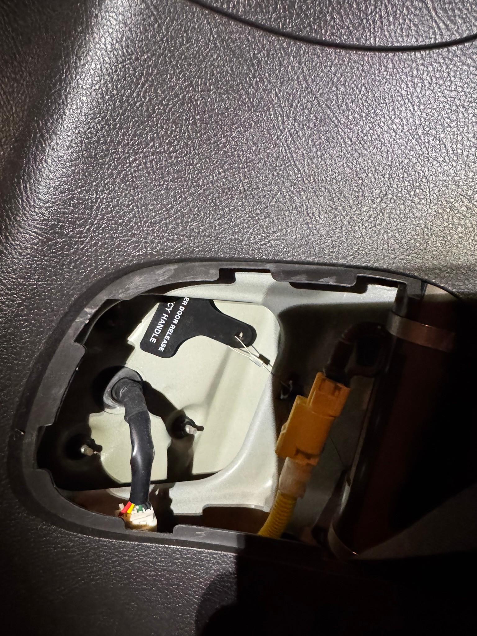 Tail light wiring and mounting nuts visible through the access opening