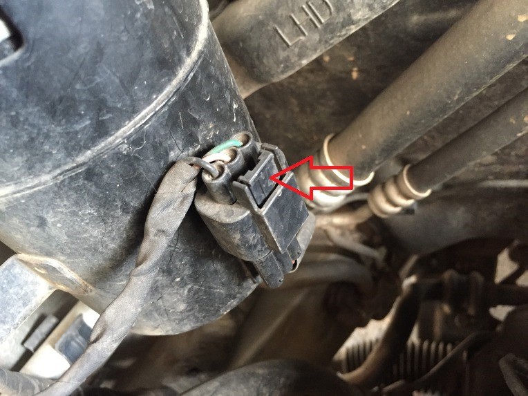 Fuel filter connector release latch indicated by a red arrow