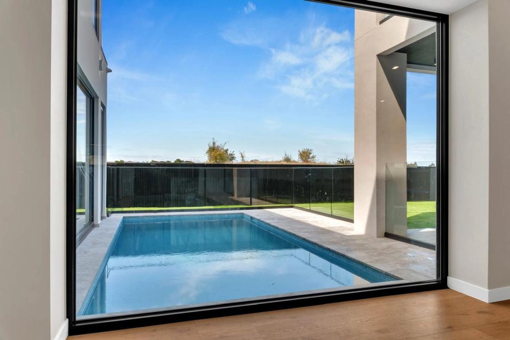 Swimming pool viewed through full-height glazing with a golf-course outlook, Tiffany Walk Residence, Melbourne