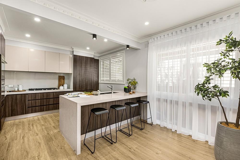 Kitchen with stone island, dark timber cabinetry and plantation shutters, Brunswick Transformation, Melbourne