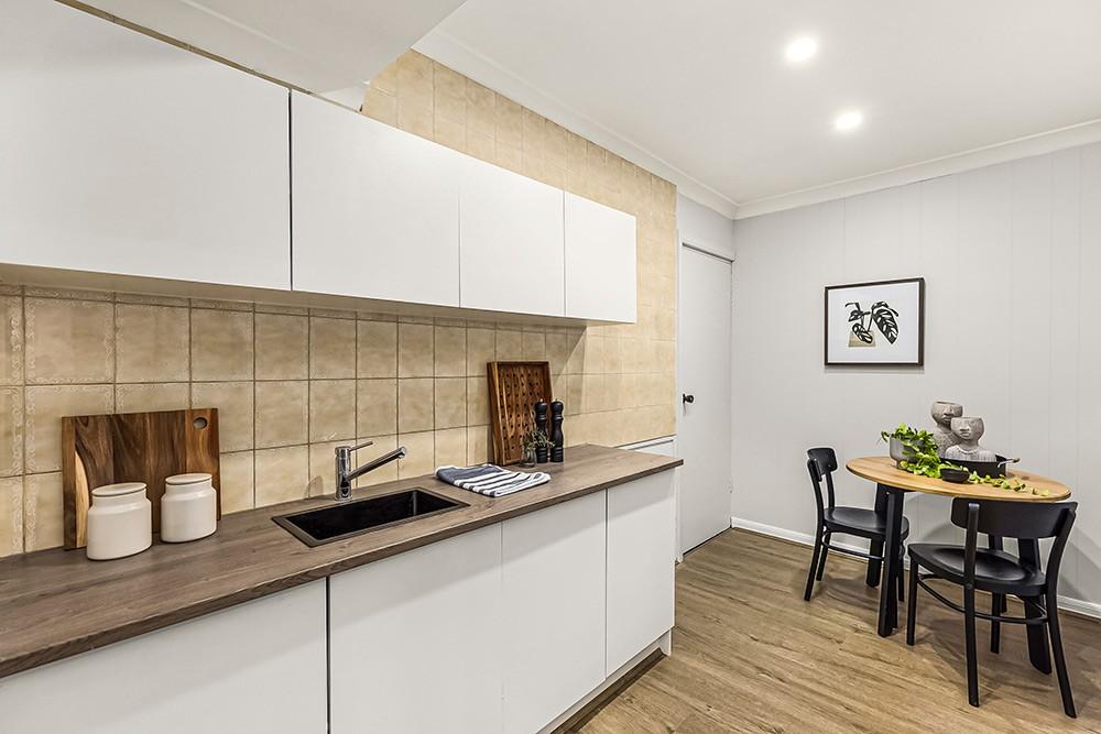 Kitchenette with tiled splashback, timber benchtop and a round dining table, Brunswick Transformation, Brunswick