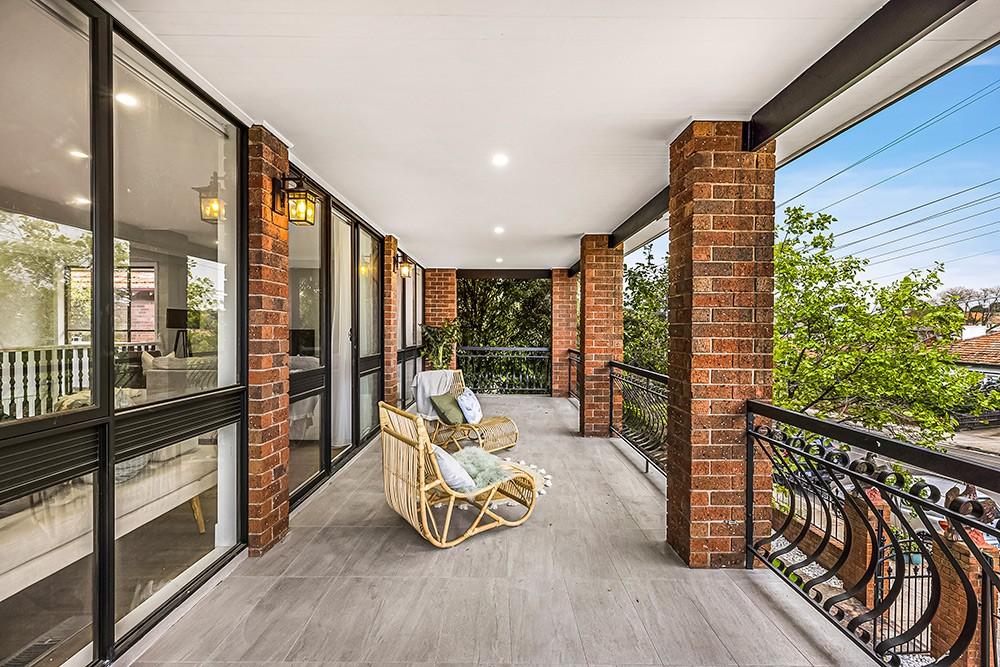 Covered brick balcony with cane seating and wrought-iron balustrade, Brunswick Transformation, Melbourne