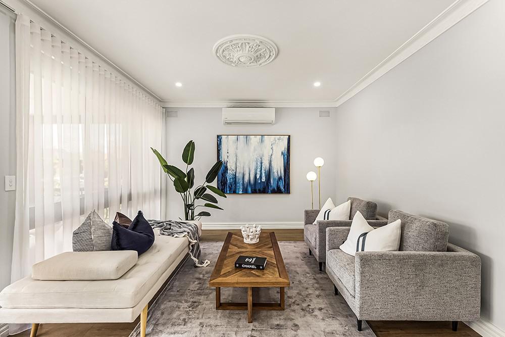 Sitting room with a cream chaise and grey armchairs beneath a ceiling rose, Brunswick Transformation, Melbourne