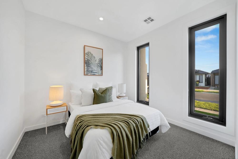 Bedroom with black-framed windows, framed art and grey carpet, Tarneit Cathedral Residence, Tarneit