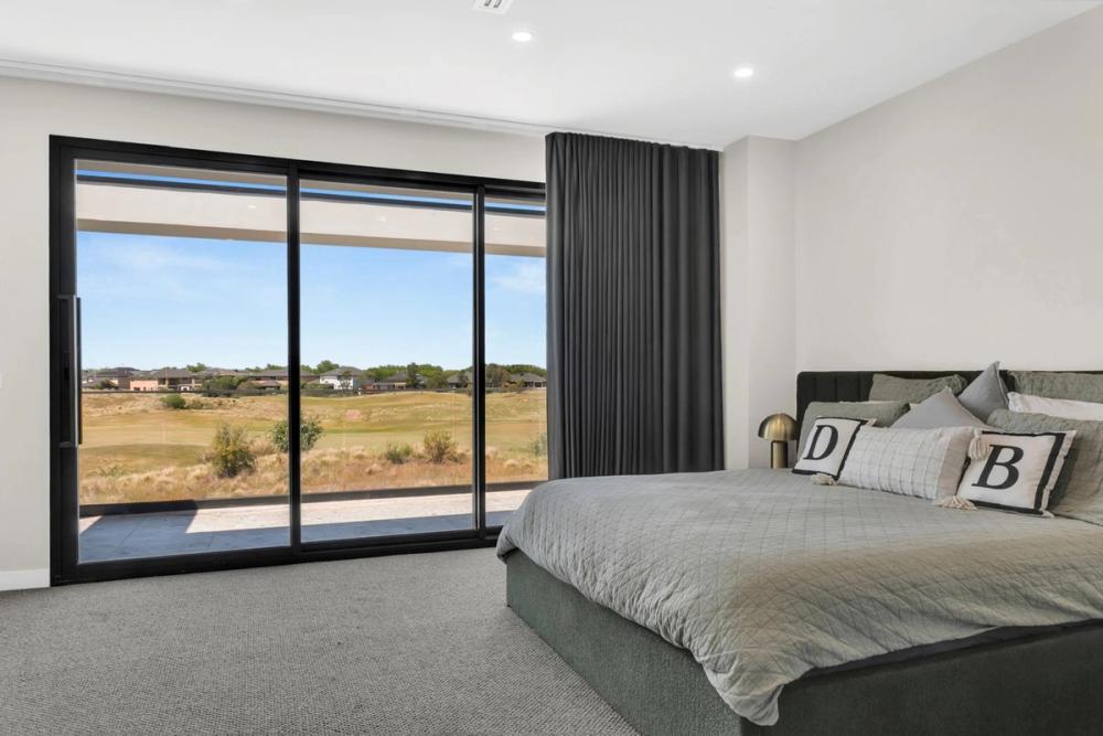 Master bedroom with floor-to-ceiling glazing framing golf-course views, Tiffany Walk Residence, Sanctuary Lakes