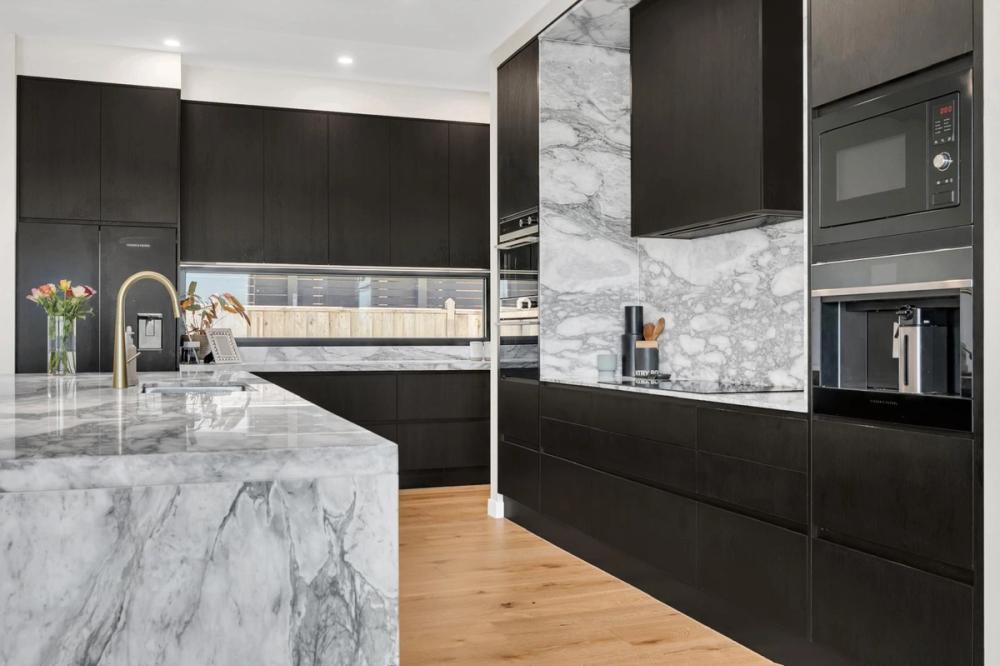 Kitchen with black cabinetry, marble splashback and gold tapware, Tiffany Walk Residence, Melbourne