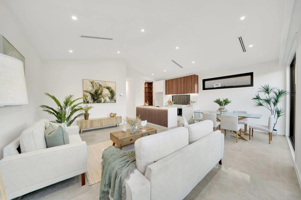Open-plan living and dining with a high ceiling and white sofas, Tarneit Cathedral Residence, Melbourne