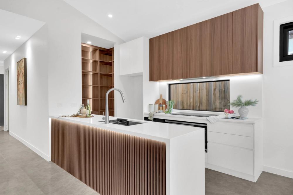 Kitchen with a fluted island bench and timber cabinetry, Tarneit Cathedral Residence, Tarneit