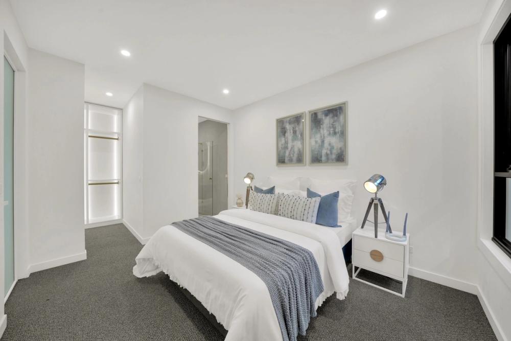Bedroom styled in grey and blue with framed art, Tarneit Cathedral Residence, Melbourne