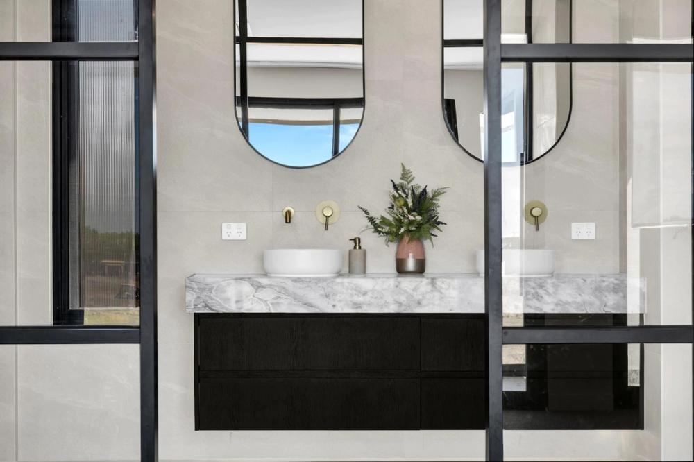 Bathroom with twin arched mirrors, a marble vanity and gold tapware, Tiffany Walk Residence, Melbourne