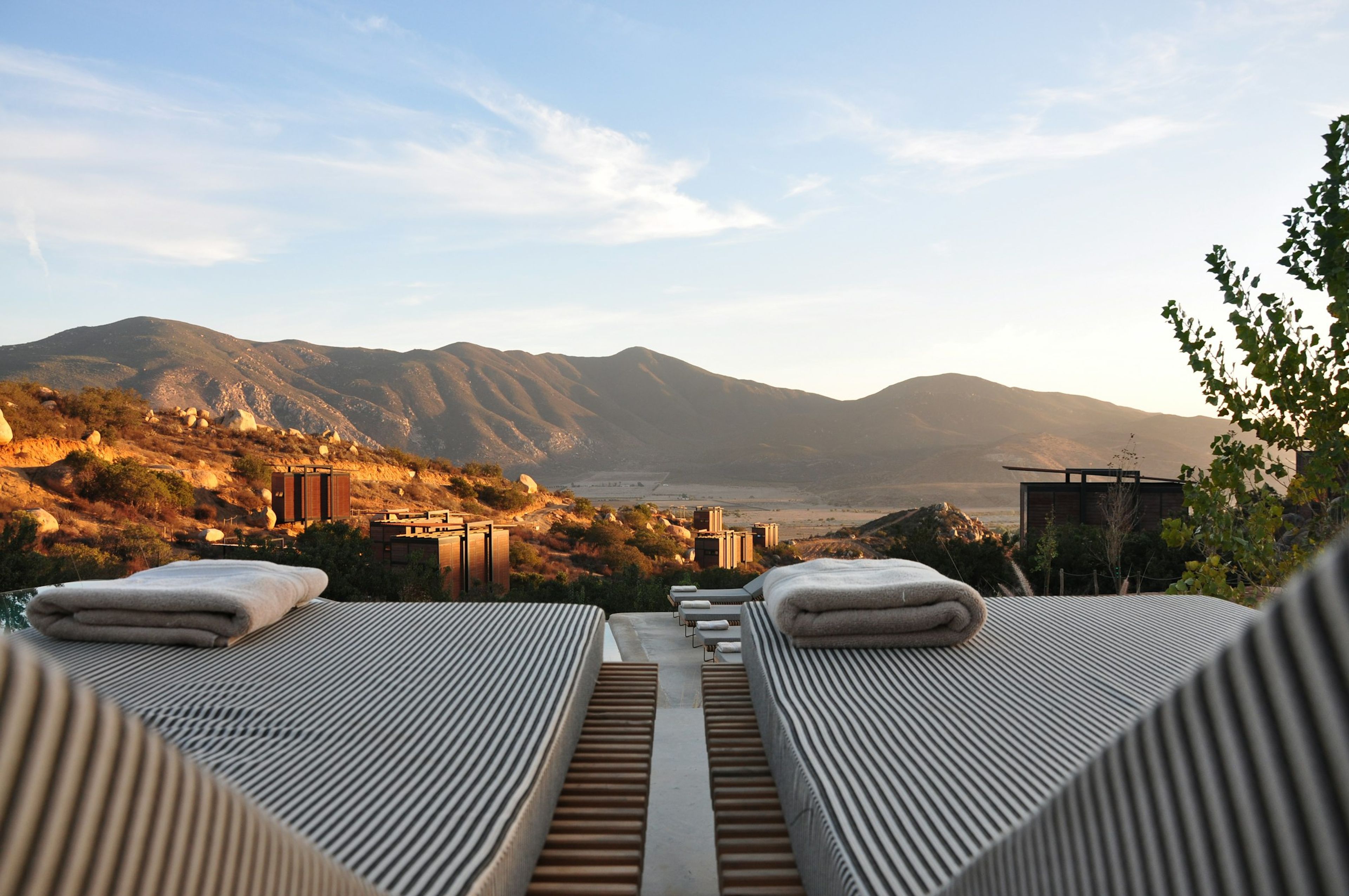 Rooftop daybeds at sunrise with mountains beyond