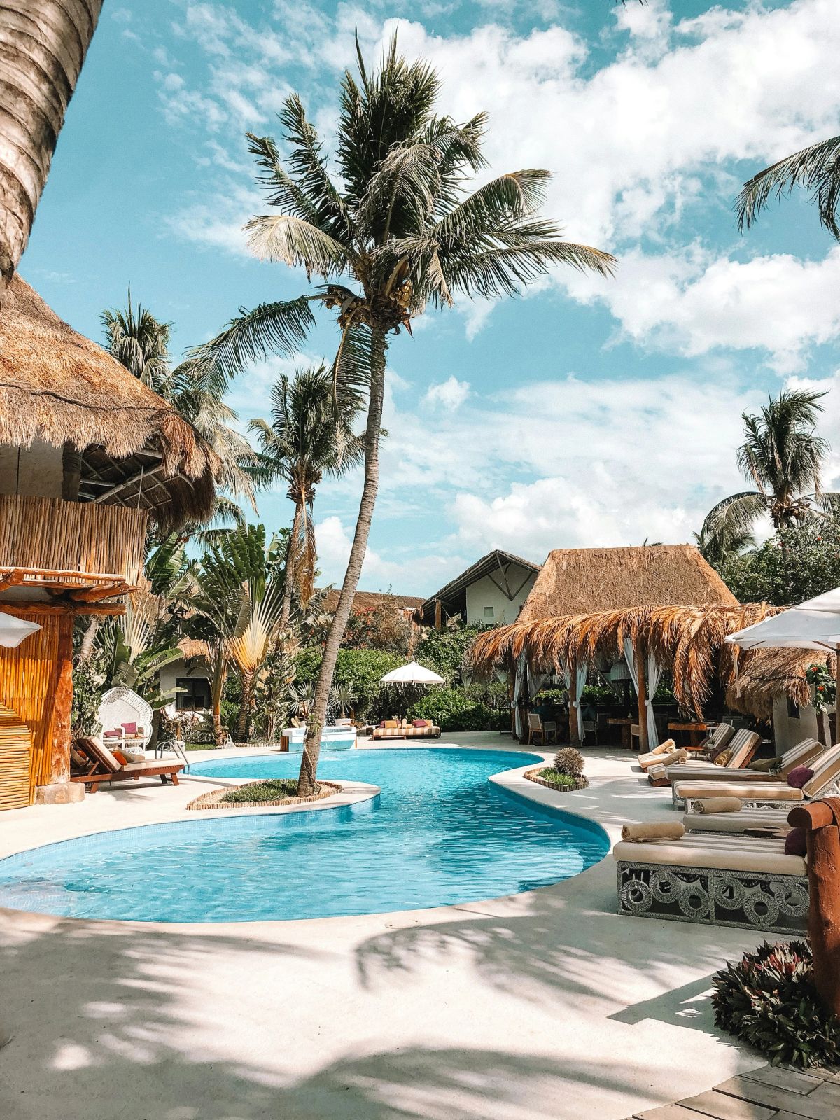 Lagoon pool with thatched sala and palm trees