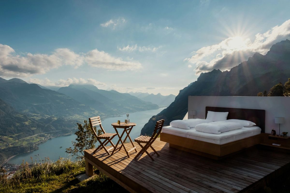 Bed on an open-air terrace overlooking mountains and water