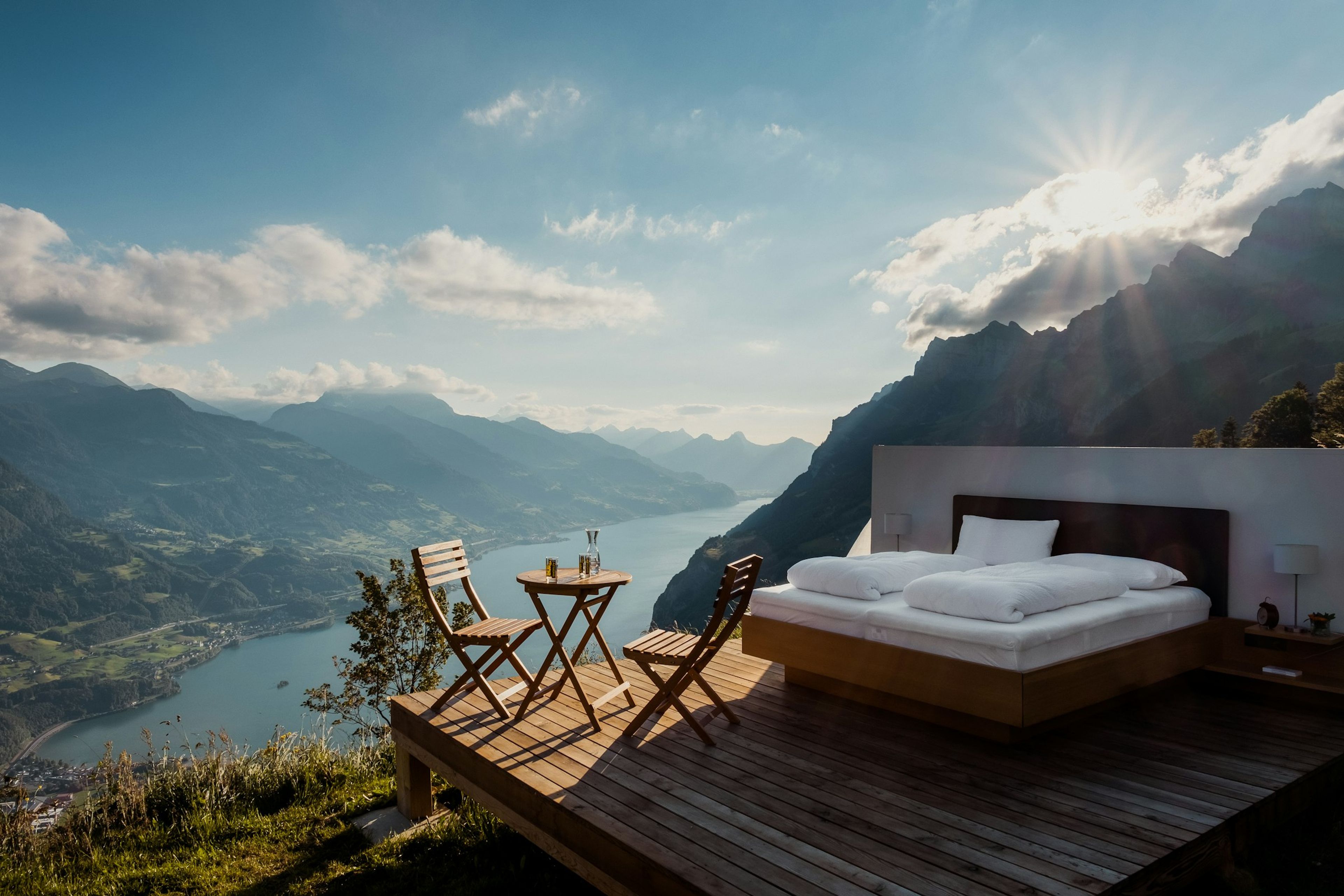 Bed on an open-air terrace overlooking mountains and water