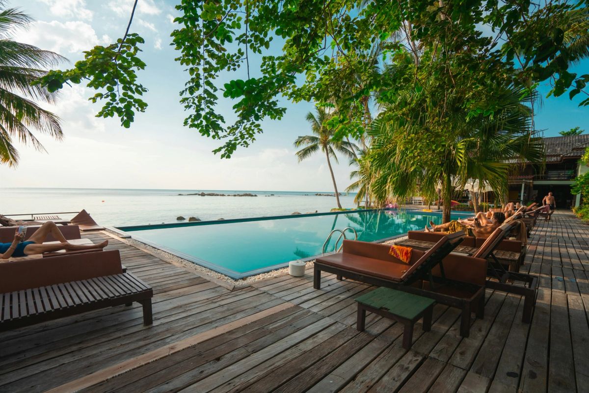 Sun loungers on a deck beside an infinity pool facing the sea