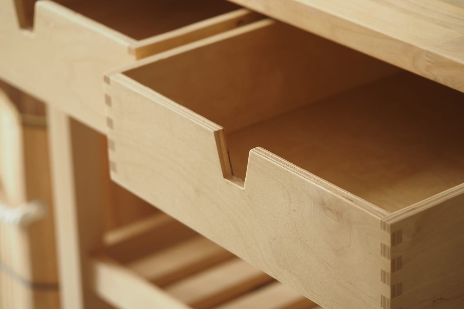 Close-up of open drawers in light wood cabinetry
