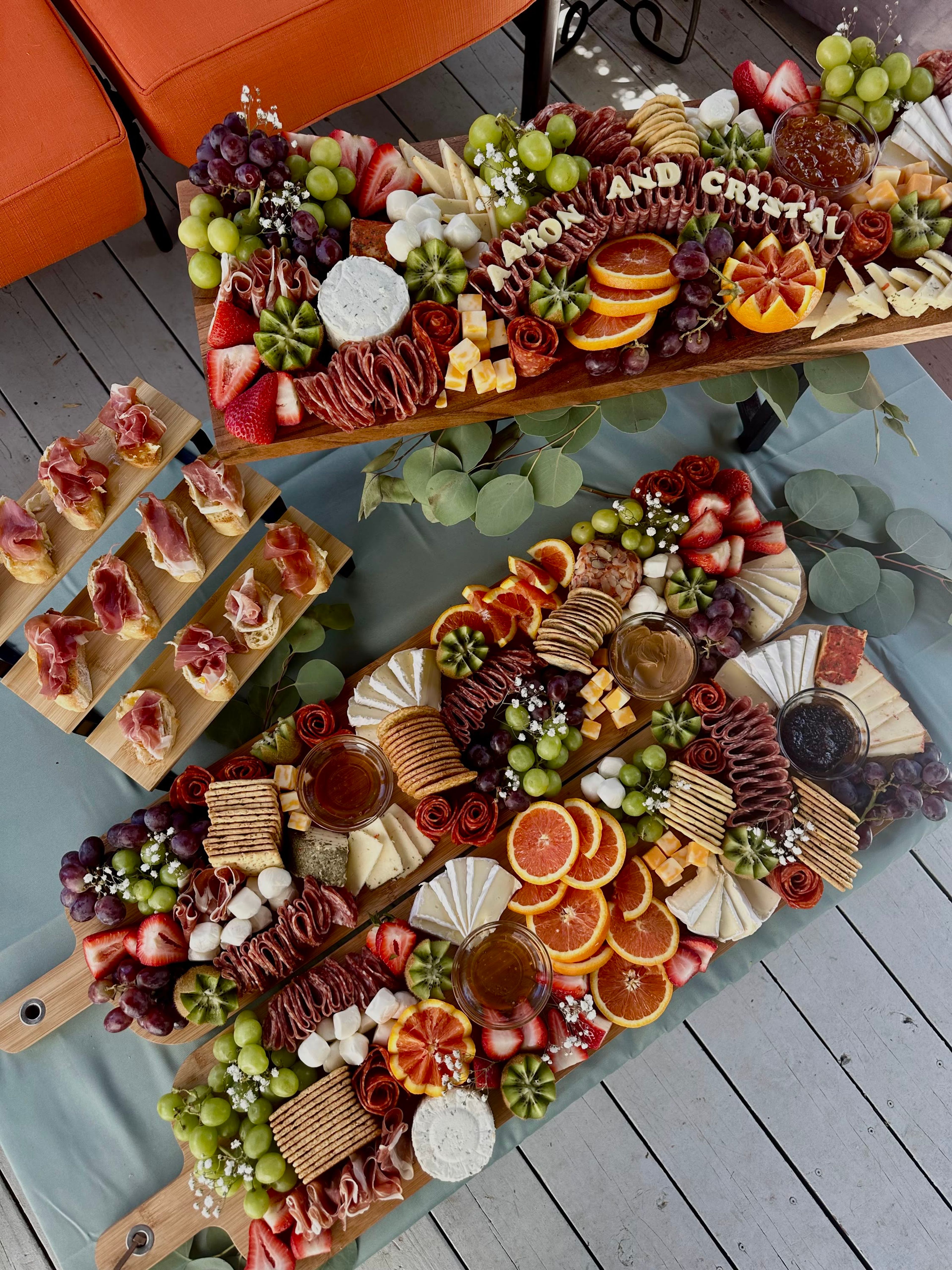 Tiered boards of cured meats and cheeses on a deck