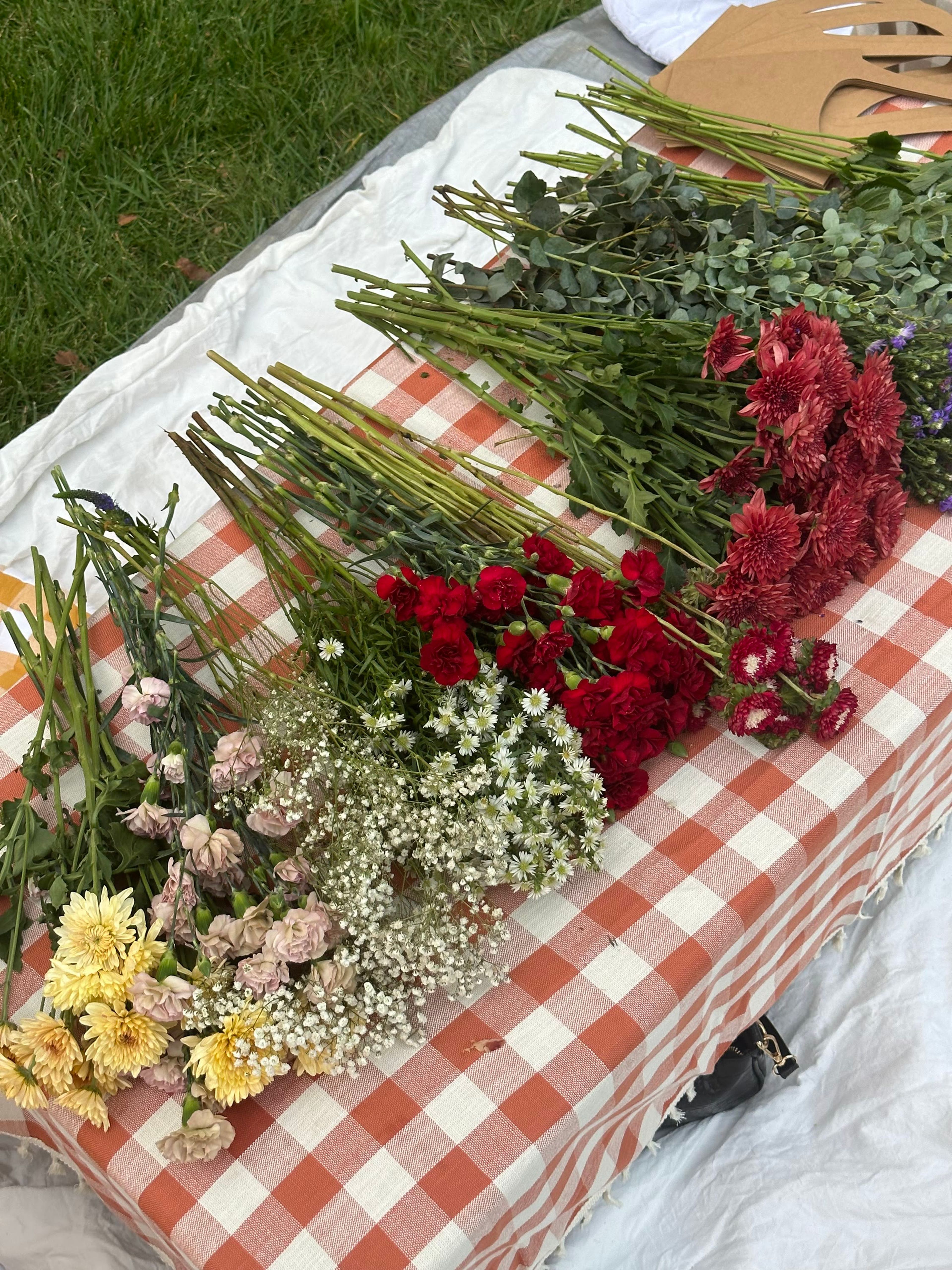 A gingham table laid with fresh cut flowers