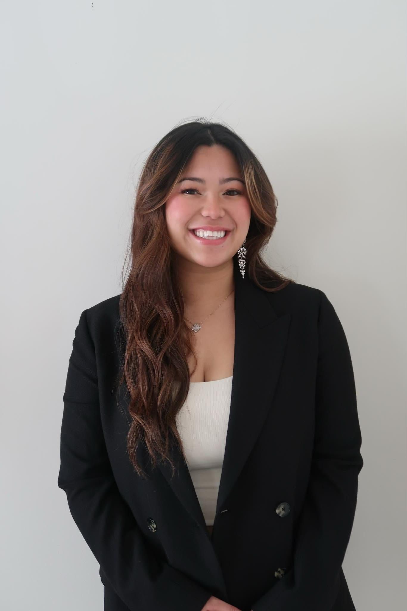 A portrait of the founder of Taste of Company, smiling, in a black blazer