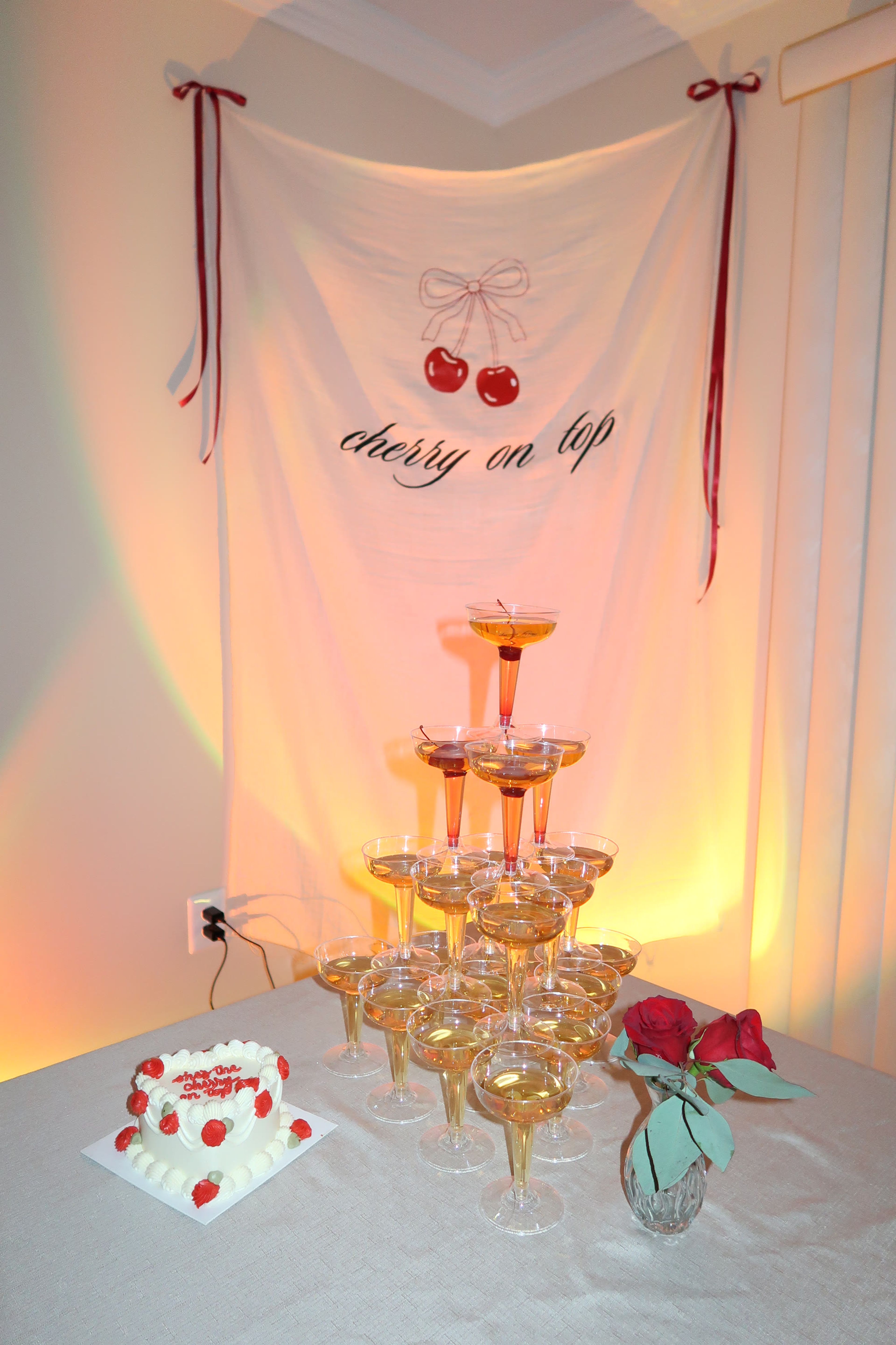 A champagne tower beside a heart-shaped cake