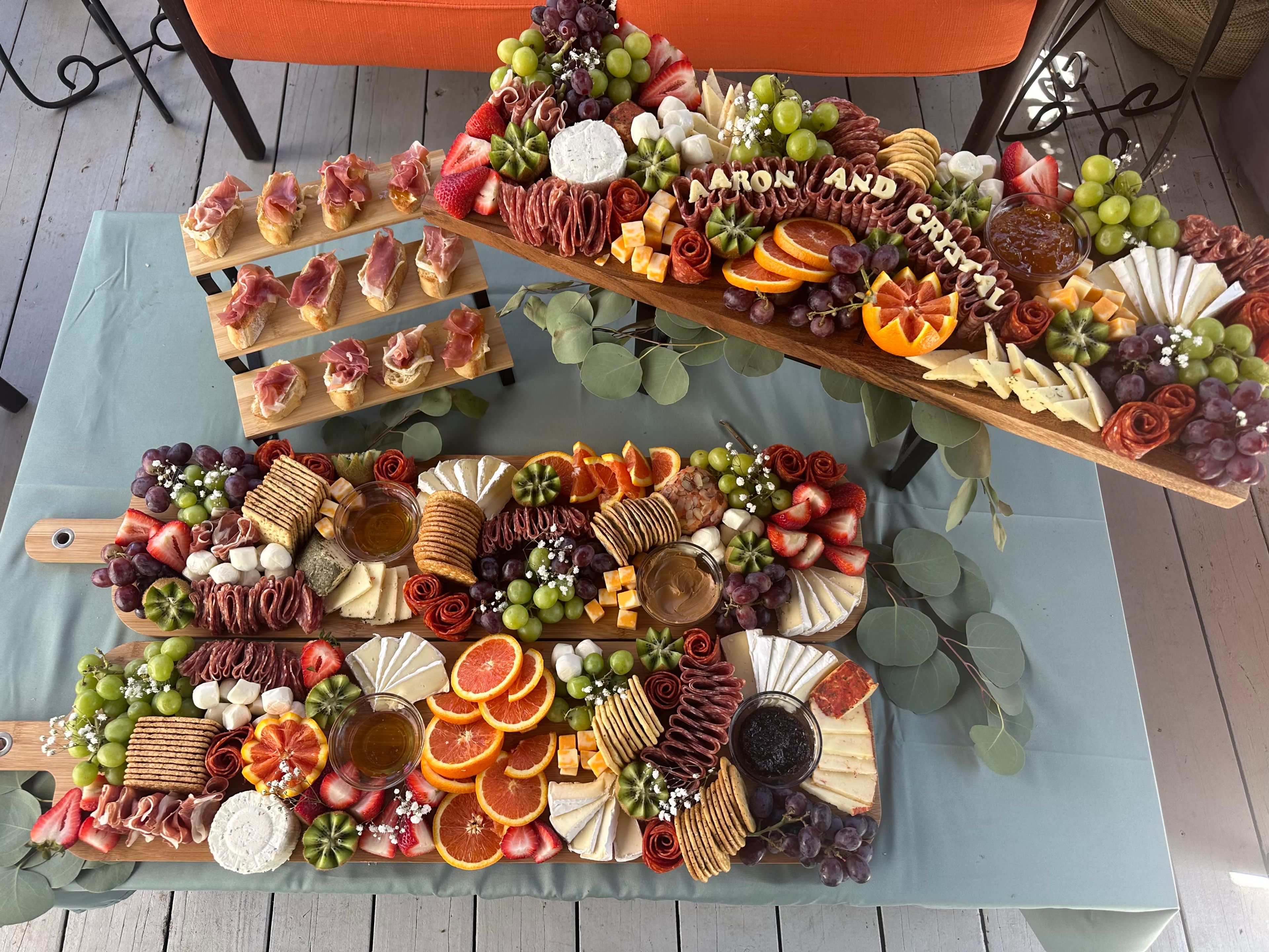 An outdoor dessert display of macarons and fruit on the grass