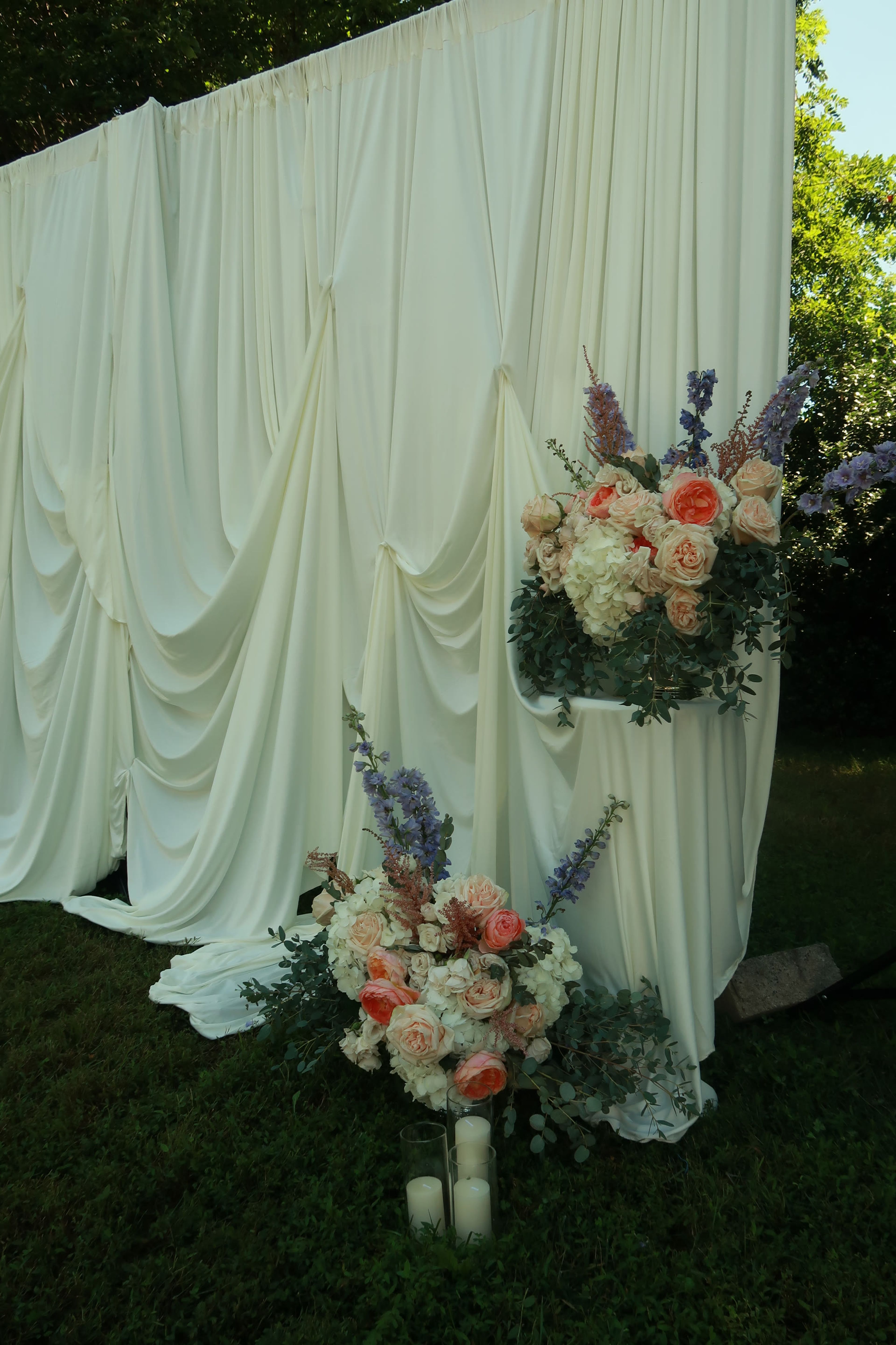 Cream drapery with a spray of peach and white blooms
