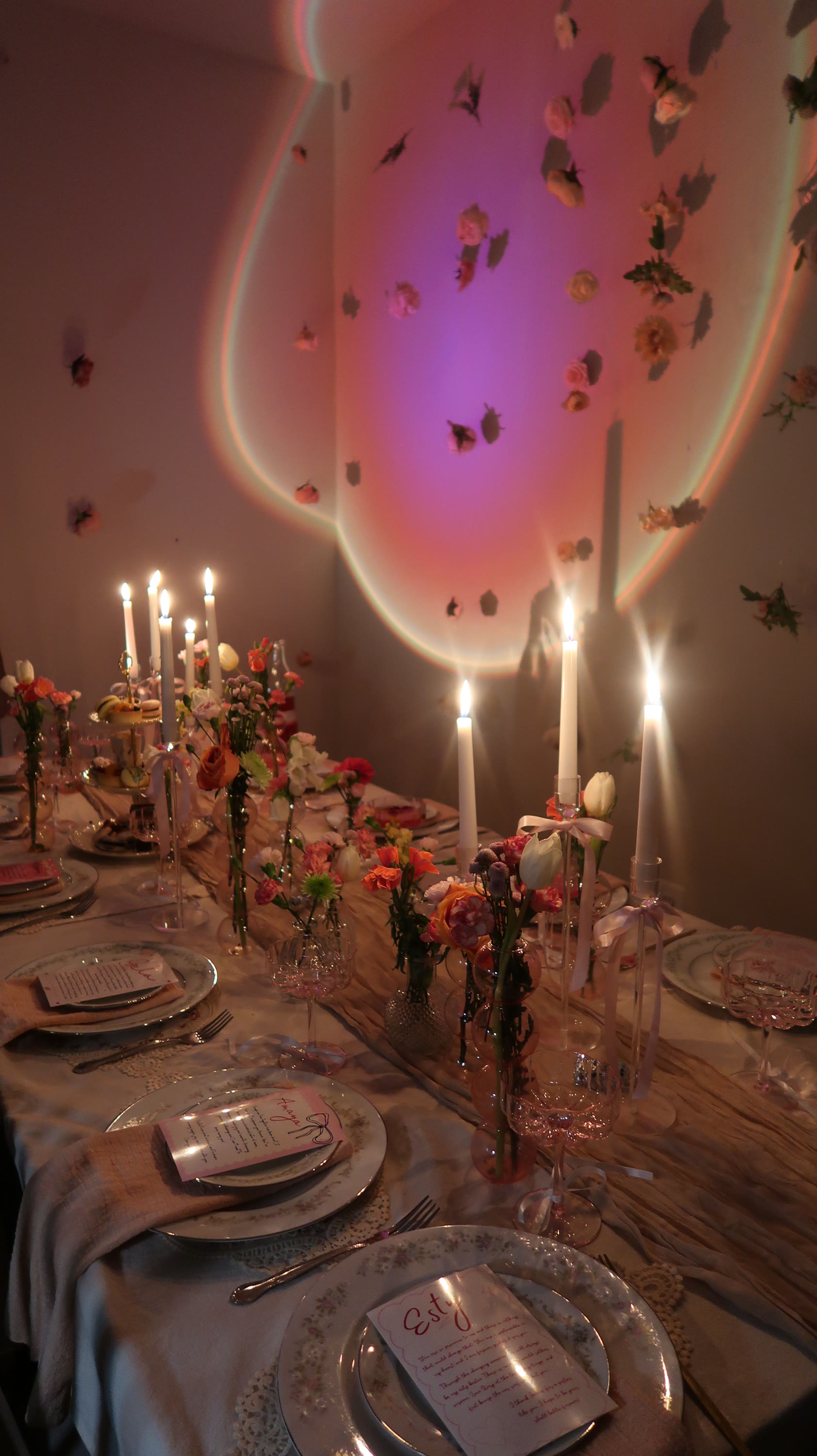 A candlelit table against a wall lit with butterflies