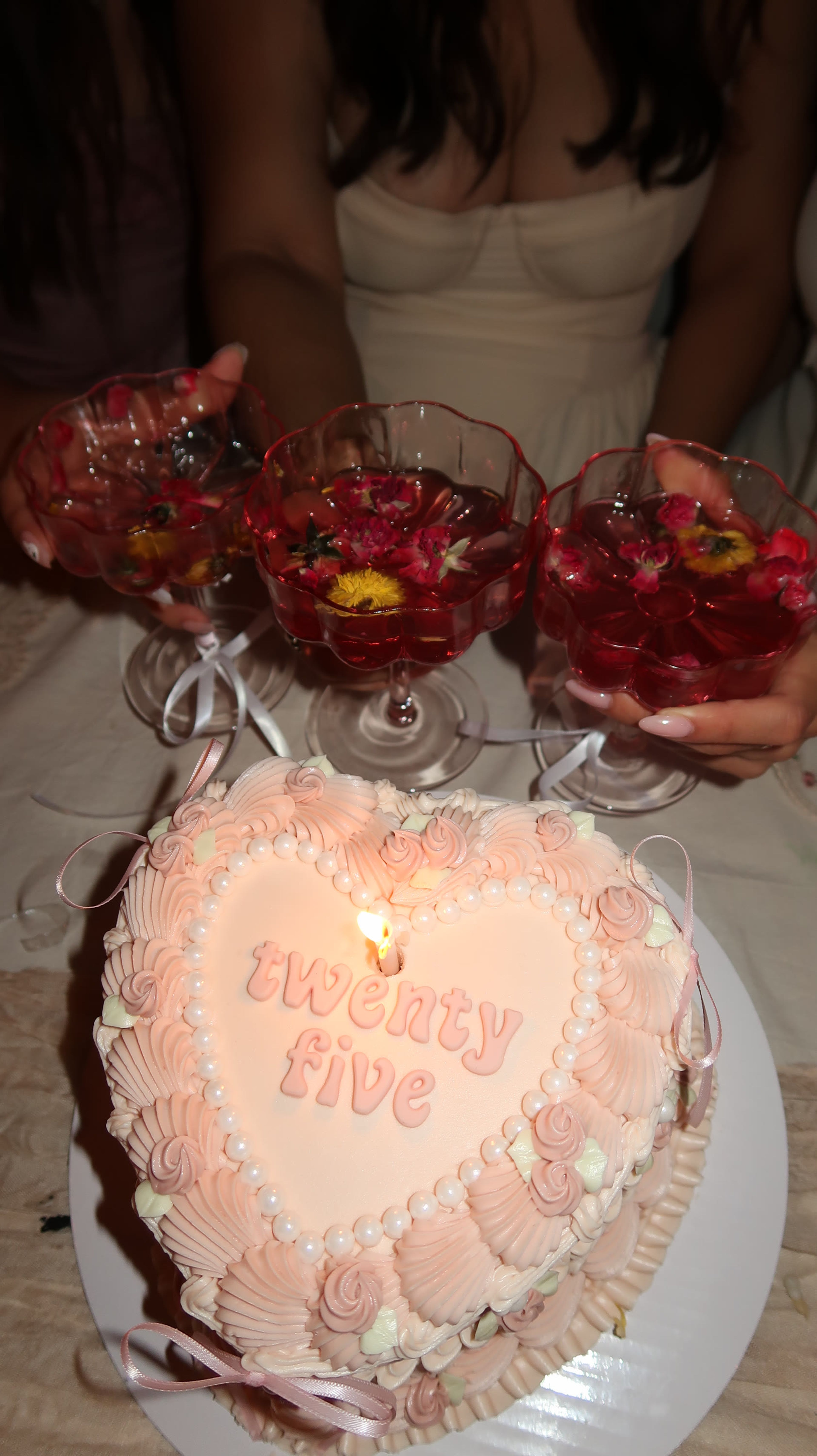 Coupe glasses of a red drink beside the birthday cake