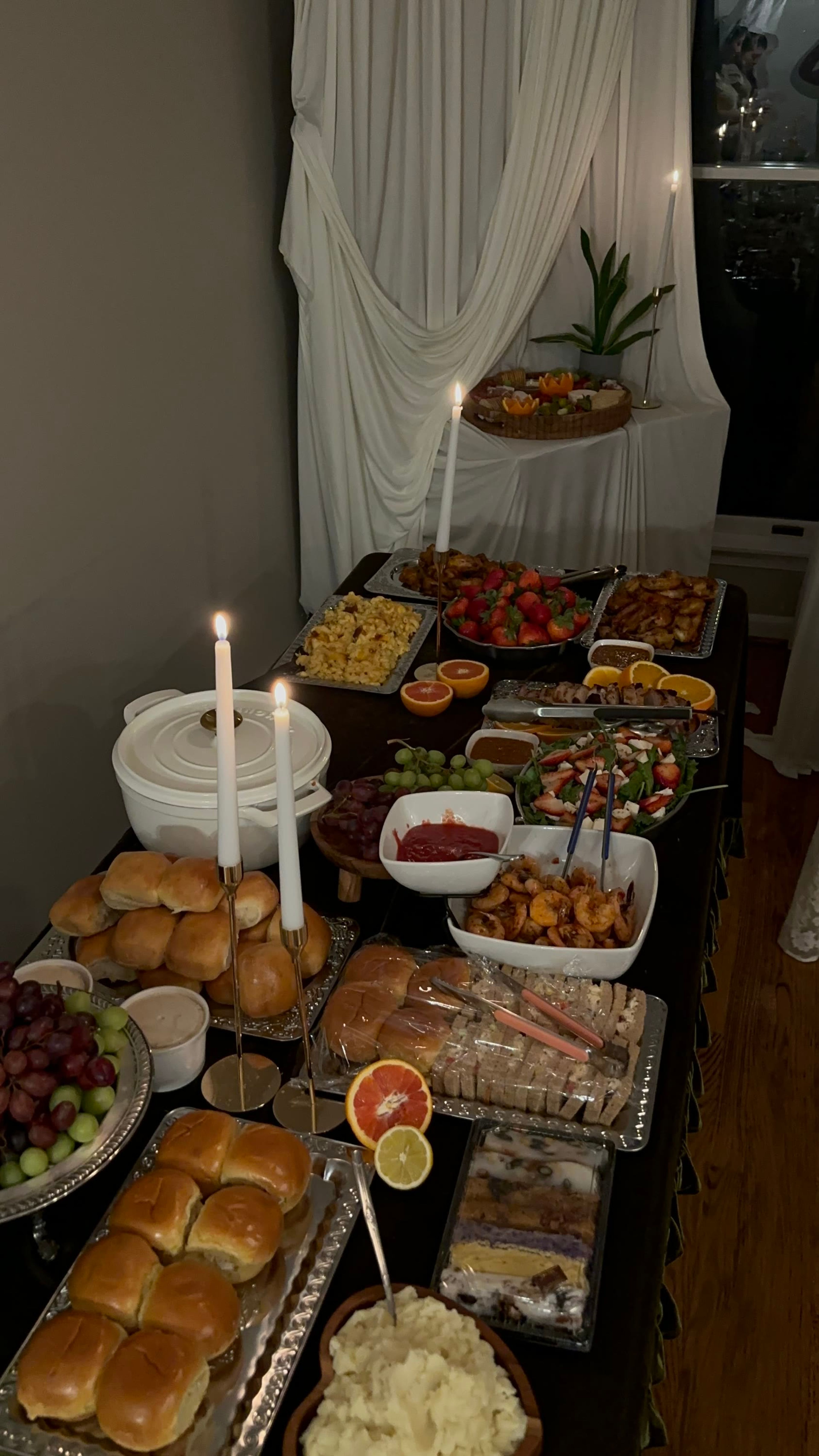A candlelit buffet of breads, fruit and salads