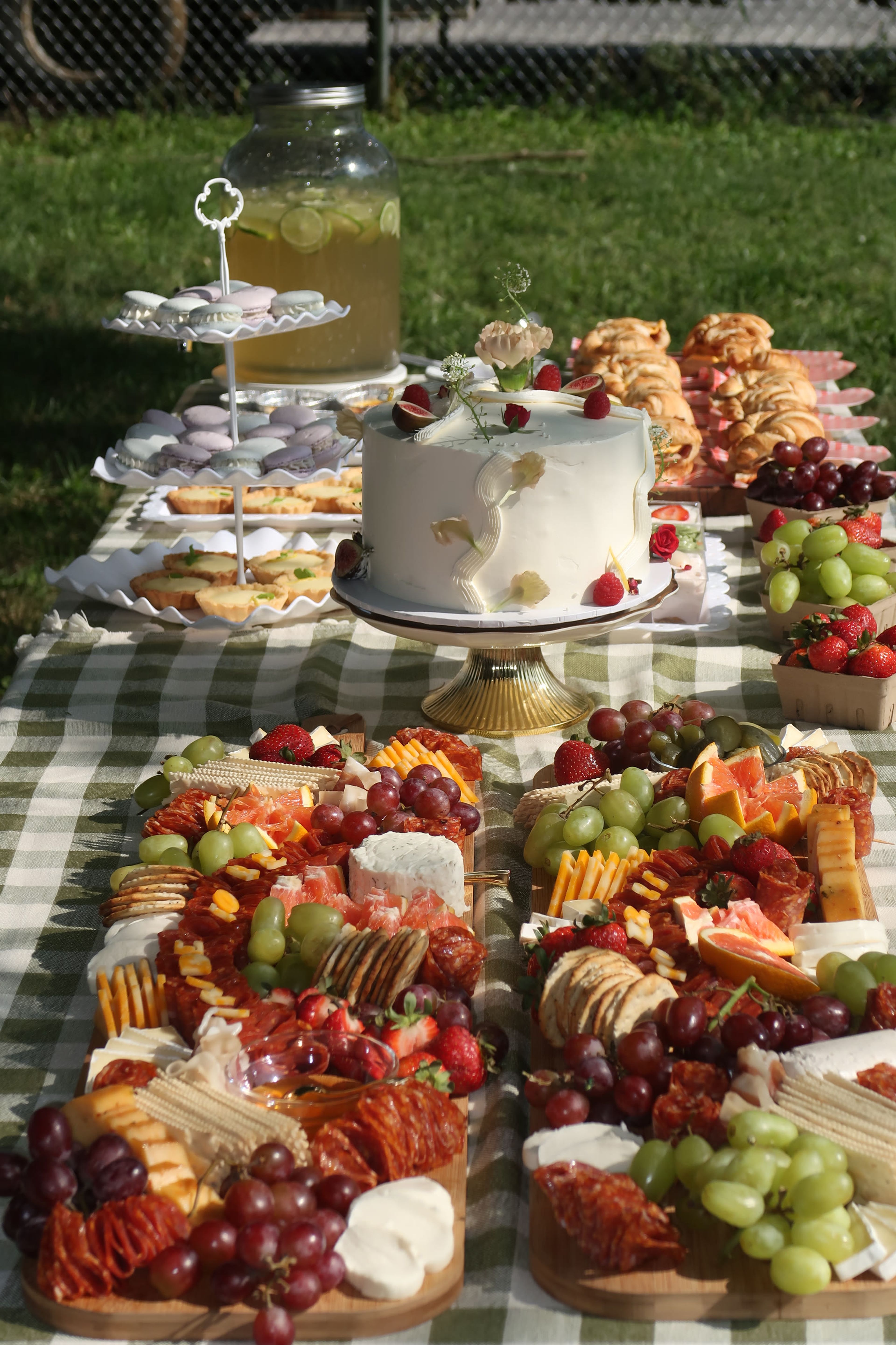 A tiered stand of meringues beside a decorated cake