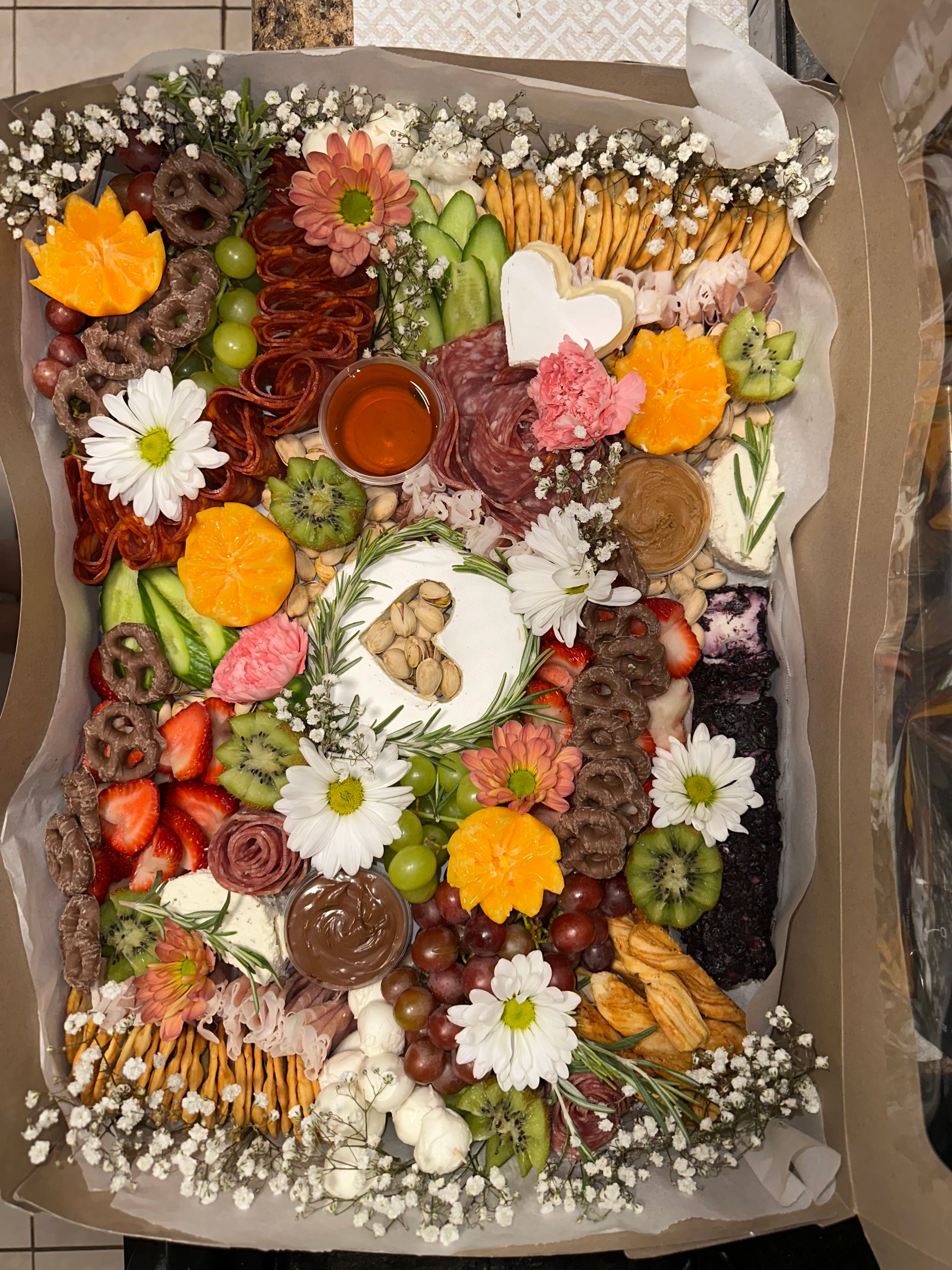 An overhead board of daisies, chocolate and fresh fruit