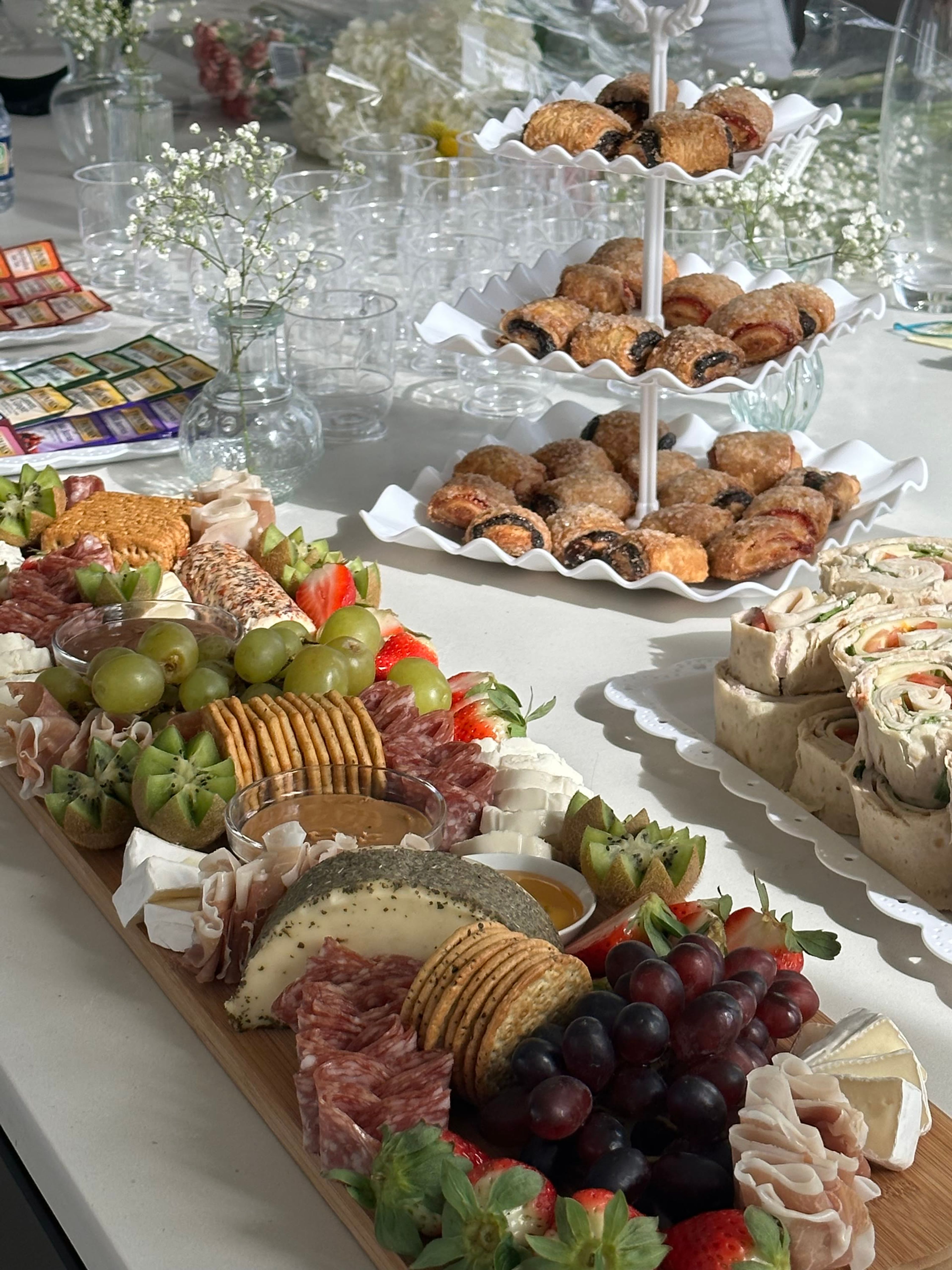 A table of boards and desserts with a city view behind