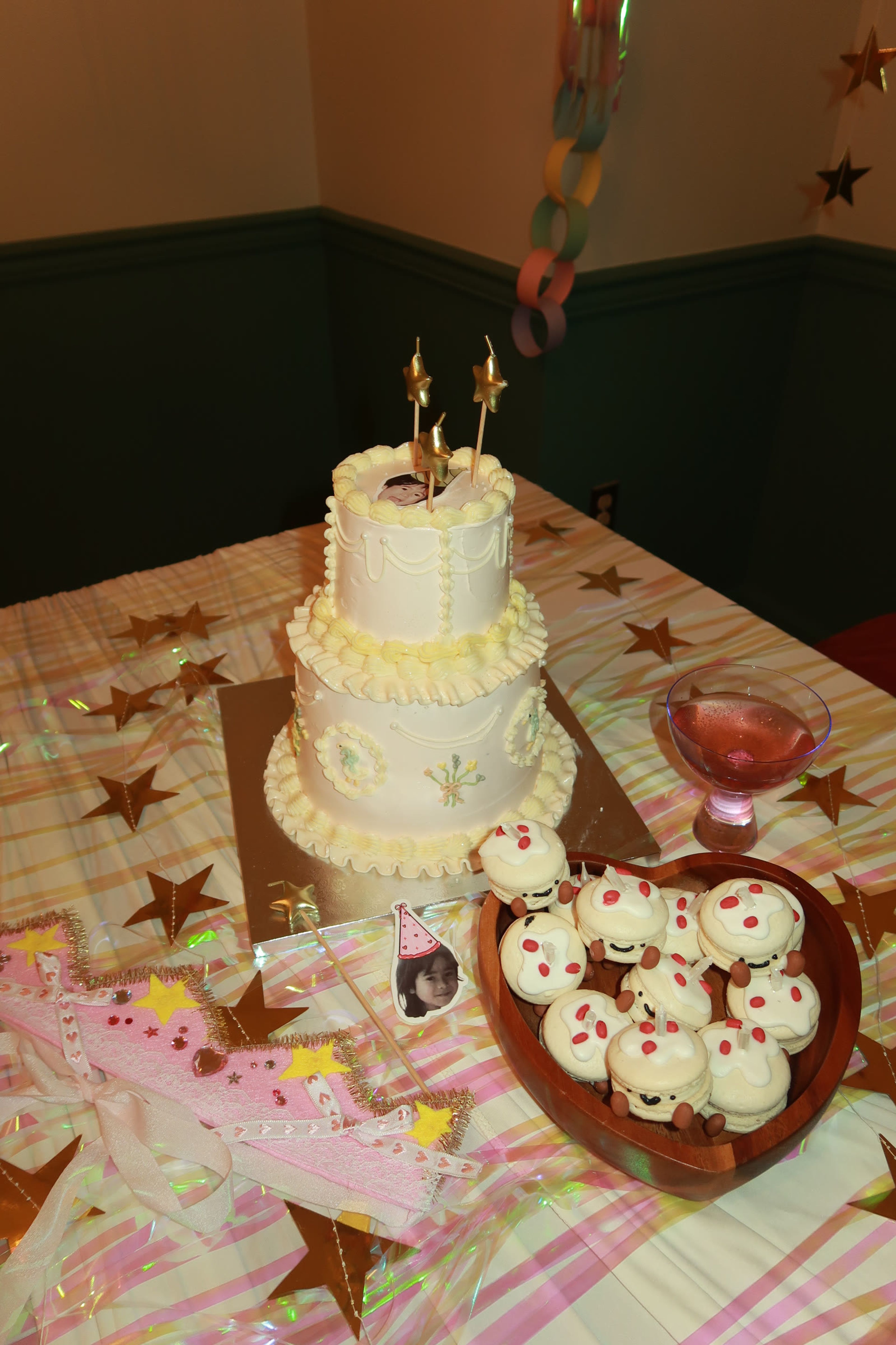 A tiered cake topped with gold stars on a starred tablecloth
