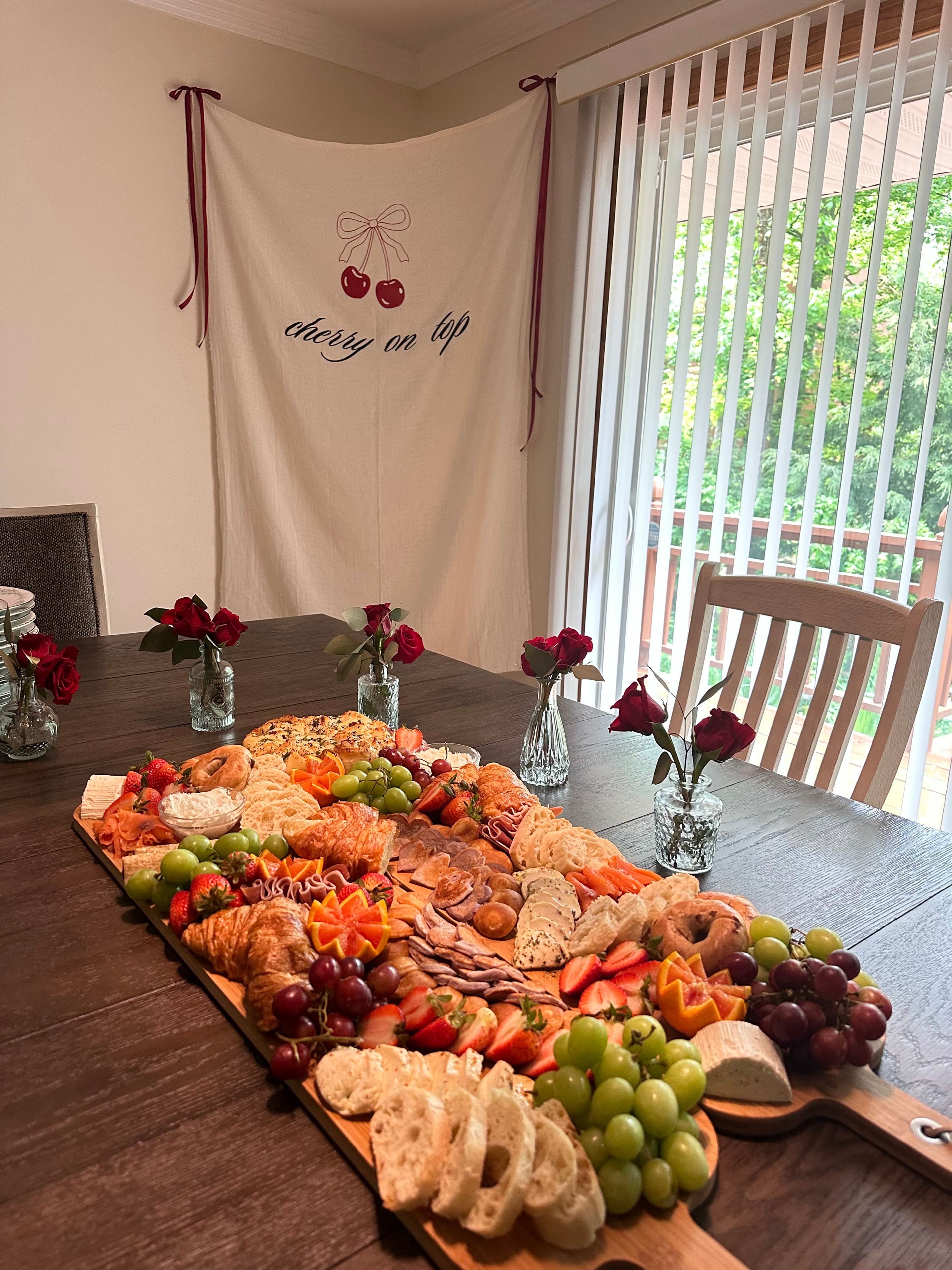 A long board of pastries and fruit on a wooden table