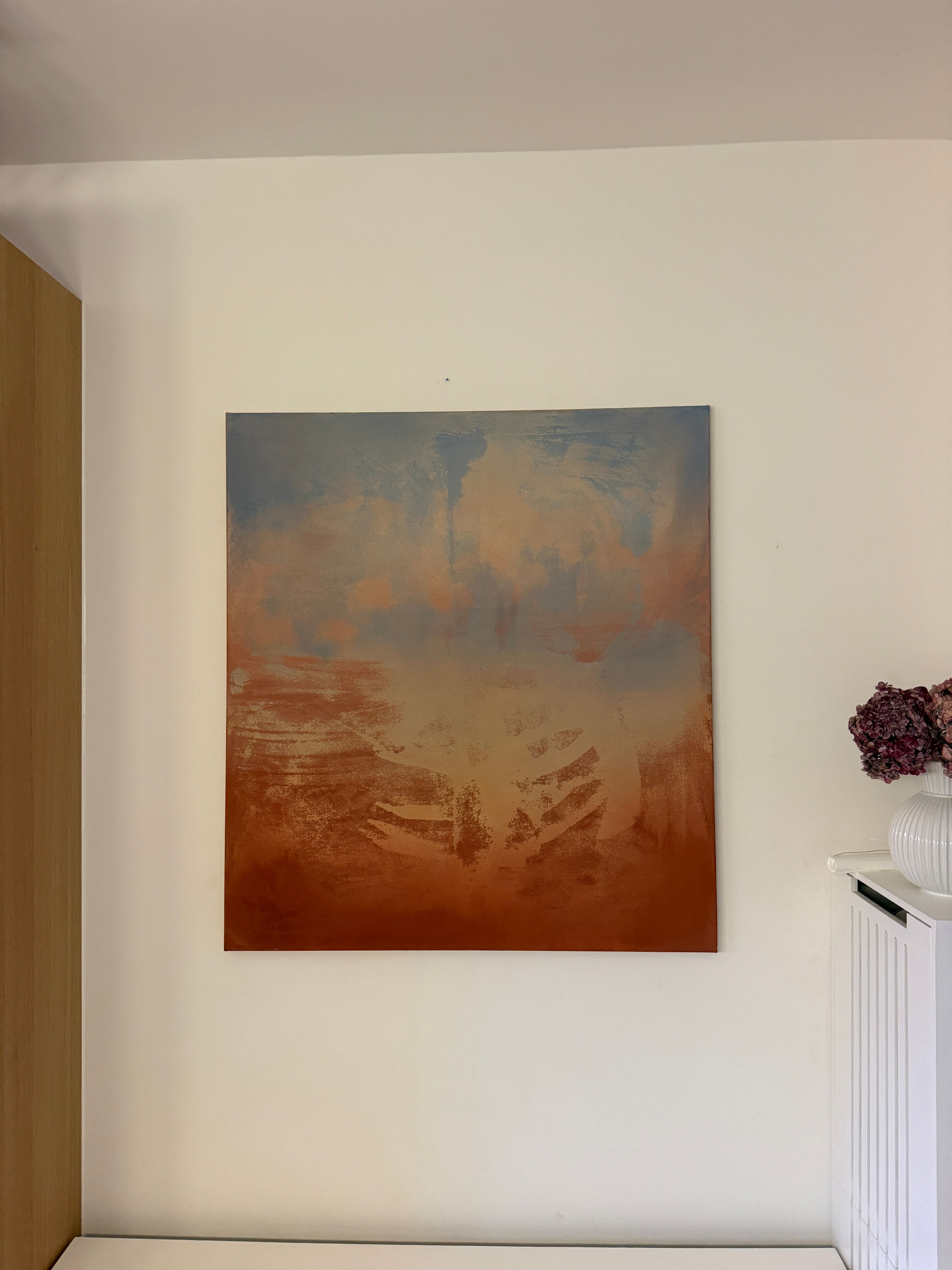 Abstract painting in a near square format. Soft sky blue at the top dissolves into warm sand and terracotta, with feathery, sweeping strokes in the lower half that suggest wind across dunes.