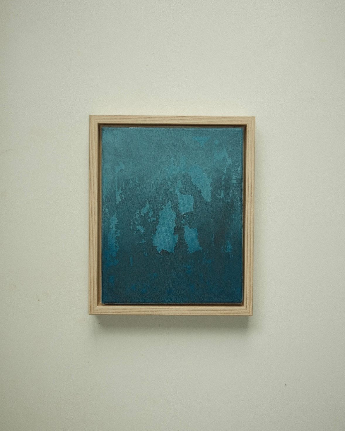 Dark blue-green abstract with lighter, mottled patches breaking through the surface.