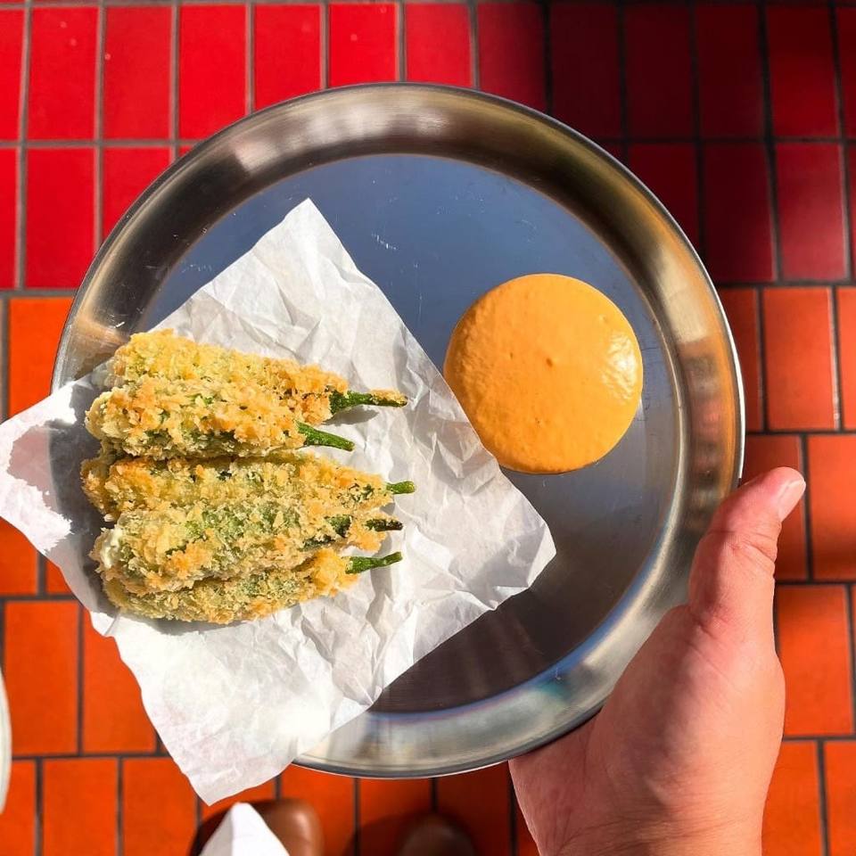 Crispy fried green chillies with orange dipping sauce on a silver plate, Boodle Fight Stirchley