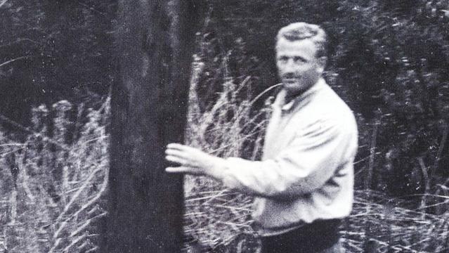 Peter Van Dyke with charred surfboard, Trestles, mid '50s