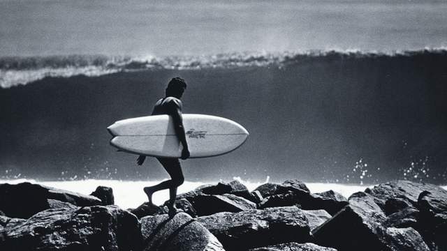 David Nuuhiwa with a walled-up wave in the background, Newport, mid 1970s