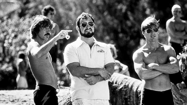 John Milius (center) with Gerry Lopez (left) and Jan-Michael Vincent, on Big Wednesday set