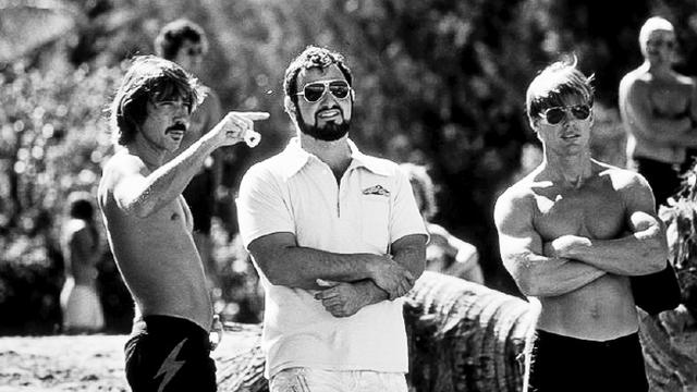 John Milius (center) with Gerry Lopez (left) and Jan-Michael Vincent, on Big Wednesday set