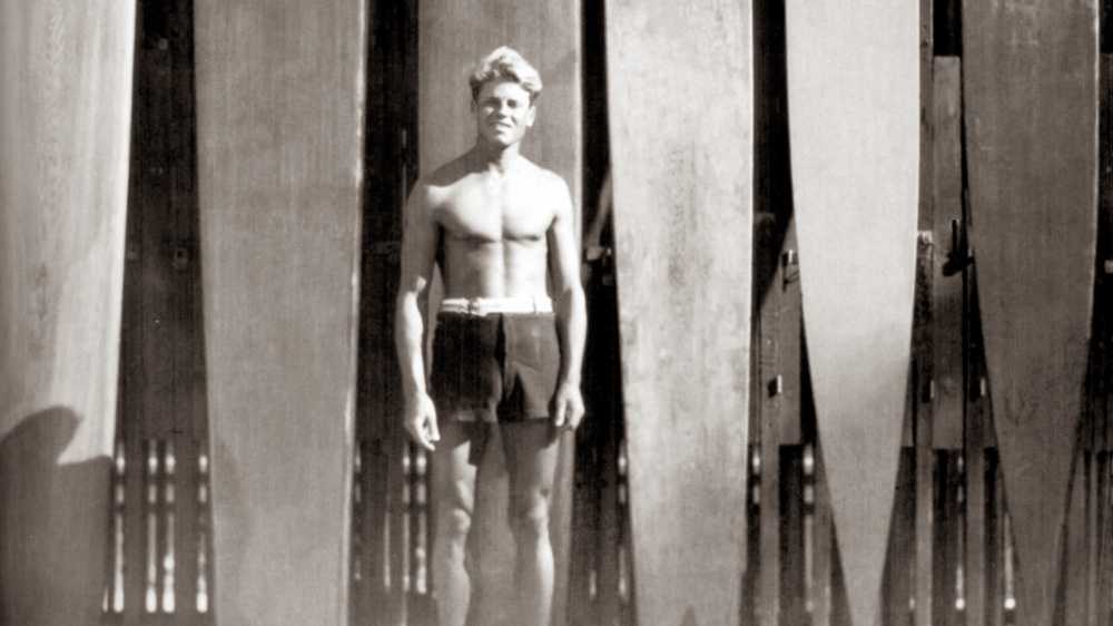 tom blake in waikiki with his collection of surfboards